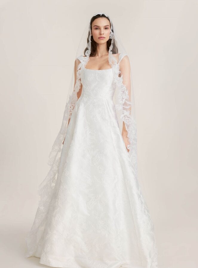 Woman wearing a white, floor-length wedding dress with lace details and a long lace veil—perfect inspiration for upcoming Bridal Trunk Shows.